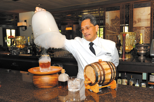 Head bartender Henry Kawaiaea unveils a Red Nichols Manhattan. For no additional cost, guests may request to have the drink infused with smoke, which deeply enhances its flavor LAWRENCE TABUDLO PHOTOS 