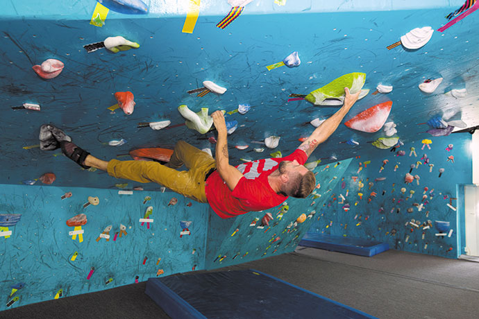 Volcanic Rock Gym owner Justin Ridgely (left) bouldering along the wall's archway.