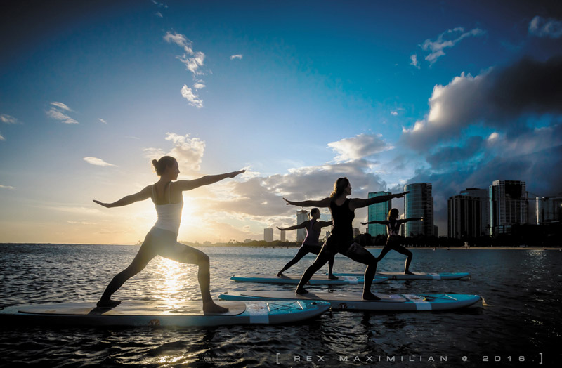 Yoga Floats students posing on SUPs at Ala Moana Beach  REX MAXIMILIAN CREATIVE PHOTOS 