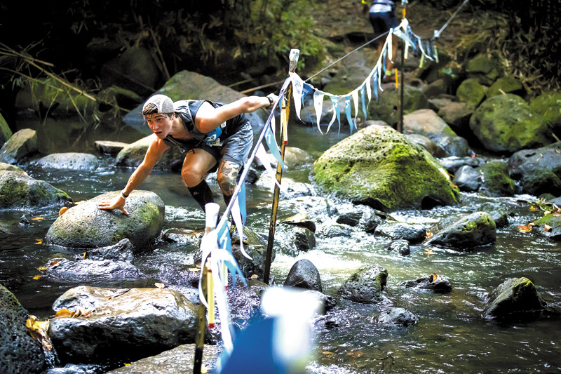Evan Berti, a 22-year-old from New Jersey, crosses a stream along the HURT 100 course PHOTO BY JAMES KAO FOTO